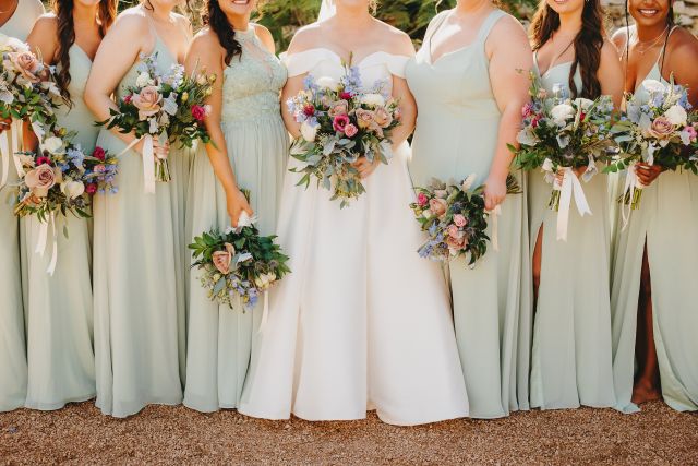 Bride and bridesmaids in sage green dresses holding pastel bouquets at Villa Antonia wedding