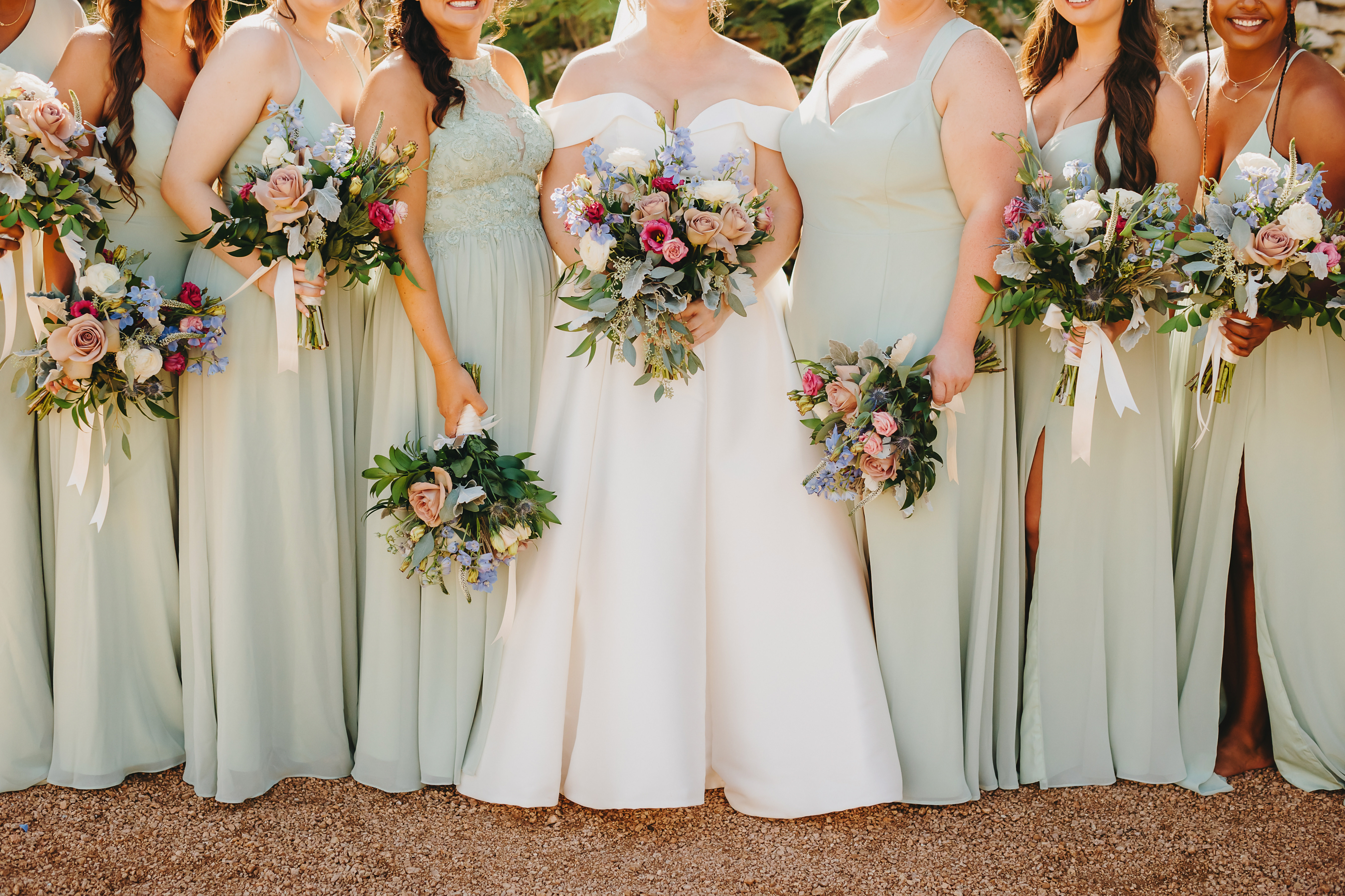 Bride and bridesmaids in sage green dresses holding pastel bouquets at Villa Antonia wedding