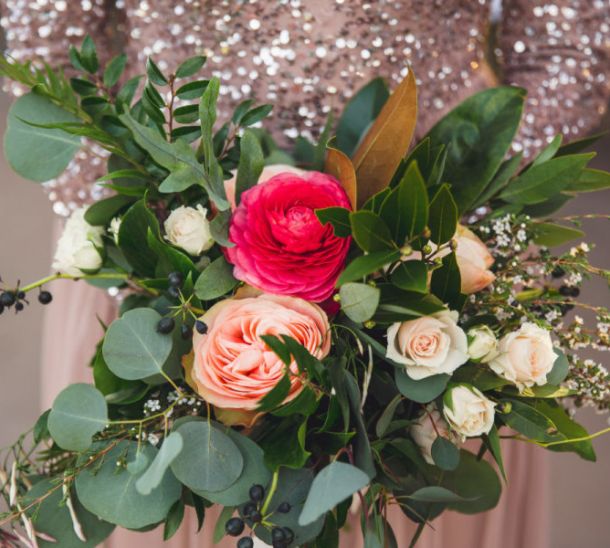 Close-up of a colorful wedding bouquet with blush and fuchsia roses, greenery, and berries at Villa Antonia